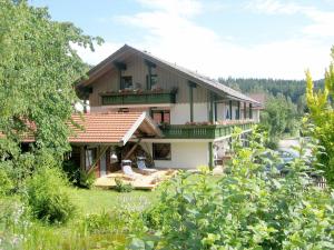 a large house with a balcony and a yard at Pension Weigert in Bodenmais