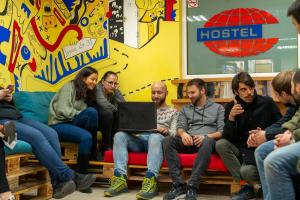a group of people sitting in a room with a laptop at Smart Hostel Sofia in Sofia