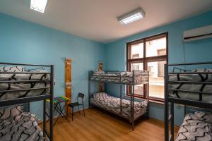 a room with three bunk beds and a window at Smart Hostel Sofia in Sofia