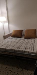 ein Bett mit zwei Kissen auf einem Zimmer in der Unterkunft S'arrulloni in Cagliari