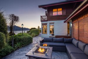 a patio with a couch and a fire pit at Matterhorn Lodge in Queenstown