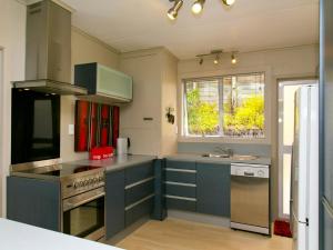 una cucina con armadi blu e un piano cottura con forno di Taupo Haven - Taupo Holiday Unit a Taupo