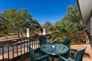 a table and chairs on a balcony with a view of a road at Alice On Todd Apartments in Alice Springs
