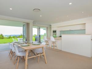 a kitchen and dining room with a table and chairs at Matakana Views - Matakana Holiday Home in Matakana