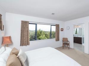una camera da letto bianca con un letto grande e una finestra di Skipper's Haven - Opua Holiday Home a Opua