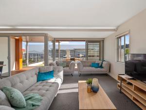 a living room with a couch and a television at Roberts Retreat - Taupo Holiday Home in Taupo