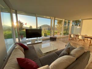 un ampio soggiorno con divano e TV di Exklusive Mini-Villa mit viel Platz a Herisau