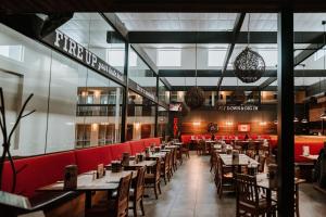 un restaurante con mesas de madera y sillas rojas en Coast Nisku Inn & Conference Centre, en Nisku