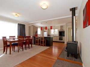 a kitchen and dining room with a wood stove at Raetihi Cottage- Raetihi Holiday Home in Raetihi