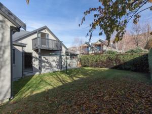 a house with a yard with a balcony on it at Modern Lake Haven - Wanaka Holiday Home in Wanaka