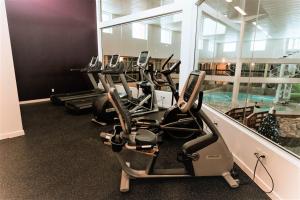 Coast Nisku Inn & Conference Centre في نيسكو: صف من آلات القلب في صالة ألعاب رياضية