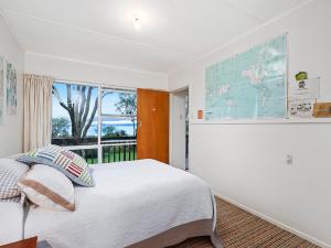 KuratauにあるKuratau Classic - Kuratau Holiday Homeの大きなベッドと窓のある寝室