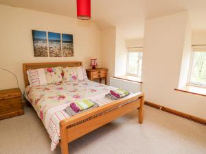 a bedroom with a bed and two windows at Plyg-y-Rhiw in West Cilrhedyn