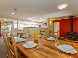 uma sala de jantar com uma mesa de madeira e uma lareira em Raetihi Garden Spa Villa - Raetihi Holiday Home em Ohakune