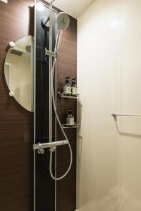 W łazience z przeszklonymi drzwiami znajduje się prysznic. w obiekcie GRAND BASE Moji Nagomi w mieście Kitakyushu