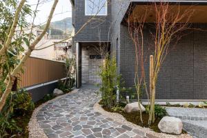 a stone walkway leading to a building with a garage at GRAND BASE Moji Nagomi in Kitakyushu