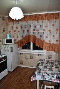 una pequeña cocina con mesa y ventana en Comfort Arenda Minsk 4 en Minsk