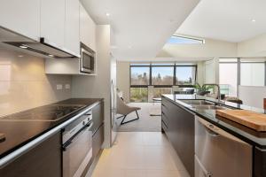 a kitchen with stainless steel appliances and a dining room at Riverside Villa - Taupo Holiday Home in Taupo