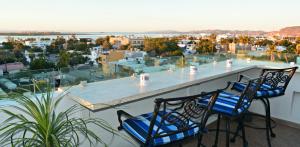 two chairs on a balcony with a view of a city at Hotel HBlue in La Paz