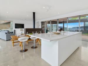 a kitchen with a large white island in a living room at Mana Sarovar - Lake Tarawera Home in Lake Tarawera