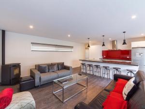 a living room with a couch and a kitchen at Central Spa Escape - Queenstown Apartment F2 in Queenstown