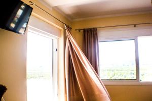 una camera con finestra, tenda e televisore di Nafplio TopView a Nauplia