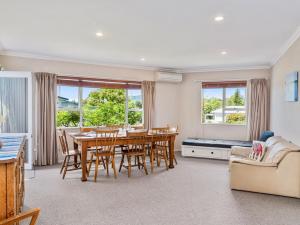 a dining room with a table and chairs and a couch at Family at Wharewaka - Wharewaka Holiday Home in Taupo
