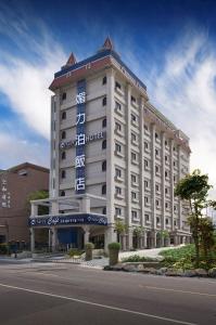 duży budynek z znakiem na boku w obiekcie Menippe Hotel Kaohsiung w mieście Kaohsiung