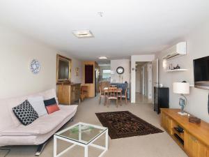 een woonkamer met een witte bank en een tafel bij Relax on Roberts - Taupo Holiday Home in Taupo
