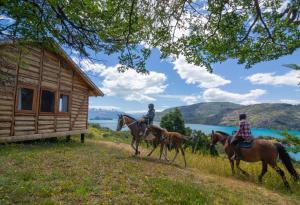 three people riding horses in front of a cabin at Mallin Colorado Ecolodge in Aldana