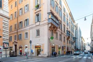 wysoki budynek przy ulicy miejskiej z zaparkowanymi samochodami w obiekcie IREX Trevi Fountain private Penthouse w Rzymie