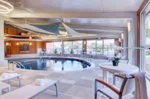 a pool in a room with a table and chairs at Best Western Plus Waltham Boston in Waltham