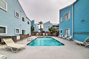 a swimming pool with lounge chairs next to a building at Corpus Christi Condo with Pool Access, Walk to Beach in Corpus Christi