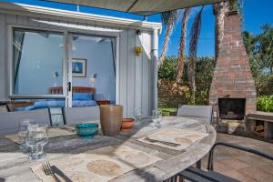 a wooden table on a patio with a fireplace at Matapouri Beach Family Haven - Matapouri Home in Matapouri