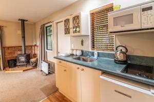 uma cozinha com um lavatório e um fogão em Overton Cottage - Akaroa Holiday Home em Akaroa