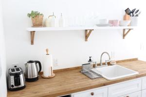a kitchen counter with a sink and a shelf on the wall at The Burlington in Los Angeles