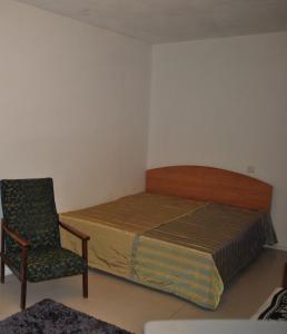 a small bedroom with a bed and a chair at Comfort Arenda Minsk 4 in Minsk