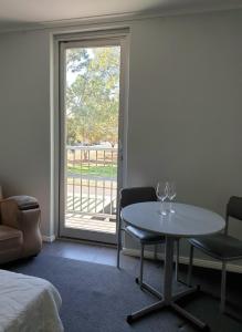 um quarto com uma mesa e cadeiras e uma janela em Adelaide Pulteney Motel em Adelaide