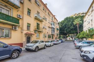 uma fila de carros estacionados numa rua ao lado de edifícios em Alferez I by ELE Apartments em Málaga