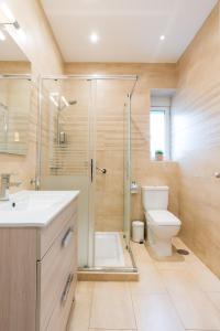 uma casa de banho com um chuveiro, um WC e um lavatório. em Alferez I by ELE Apartments em Málaga