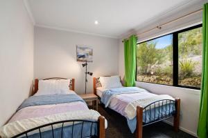 Postel nebo postele na pokoji v ubytování Hillside Hideaway - Kaiteriteri Holiday Home