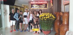 a group of people standing next to a vase of flowers at Sen Vang Luxury Hotel in Nha Trang