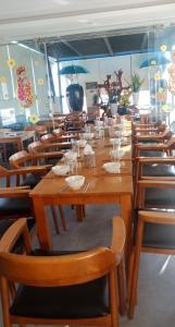 a large wooden table and chairs in a restaurant at Sen Vang Luxury Hotel in Nha Trang