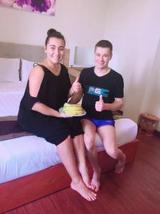 a man and a woman sitting on a bed at Sen Vang Luxury Hotel in Nha Trang