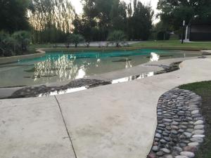 a pond with a fountain in a park at Hotel Tomaso in Chivilcoy
