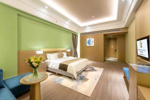 a hotel room with a bed and a vase of flowers at Metropolo Jingjiang Hotels- JiangNan market ShuangLong in Guangzhou