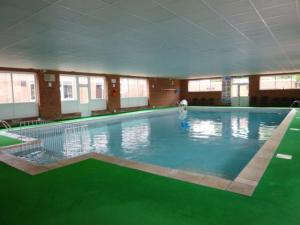 uma grande piscina com água verde num edifício em Amazing holiday home refurbished em Great Yarmouth