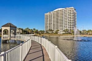 a bridge over a body of water with a large building at Snowbirds Retreat Walkable Destin Condo with View! in Destin