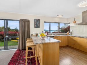a kitchen with a counter with a bowl of fruit on it at Lakeside Escape - Lake Tarawera Holiday Home in Lake Tarawera