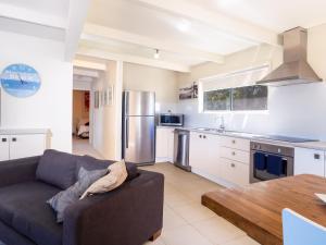a living room with a couch and a kitchen at Seaview Getaway in Dunbogan